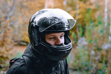 portrait of a biker, rider standing on the road. dressed in black