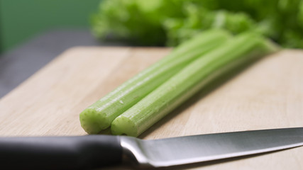 Housewife cutting celery to cook in the kitchen.