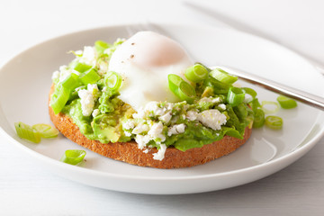 breakfast avocado sandwich with poached egg and feta cheese