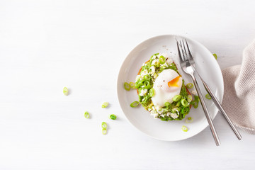 breakfast avocado sandwich with poached egg and feta cheese
