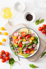 healthy colorful vegan tomato salad with cucumber, radish, onion
