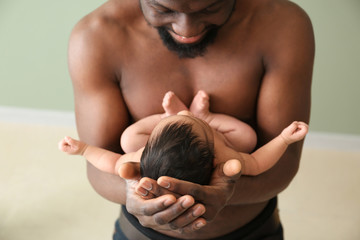 Obraz premium Happy African-American father with little baby indoors