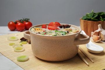 Tasty Chinese soup in pot on light table