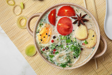 Tasty Chinese soup in pot on light table