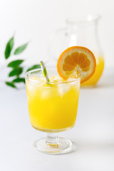 Tasty Orange Juice in Glass With Ice Cube Blue and White Background Fresh Oranges Vertical