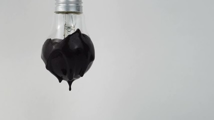Visualization of ecology harm. Lamp in blacks paint. The black paint drips. Light bulb on grey background. - Powered by Adobe