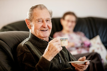 Senior trinkt zuhause zusammen mit seiner Frau eine Tasse Kaffee
