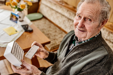 Senior nimmt seine Tabletten ein aus einer Medikamentenbox