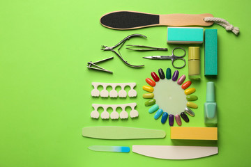 Set of professional tools for pedicure and nail polishes on color background