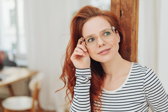 Attractive woman holding her hand to her glasses