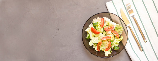 healthy salad, vegetable, tomatoes, cucumbers, iceberg, Cutlery, kitchen towel, grey background. Copy space. Vegetarian