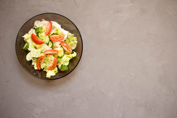 healthy salad, vegetable, tomatoes, cucumbers, iceberg, Cutlery, grey background. Top view. Copy space.