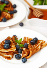 Homemade crepes with fresh blueberries and honey