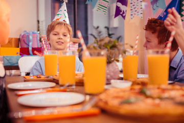 Fototapeta premium Handsome birthday boy sitting in the middle of table