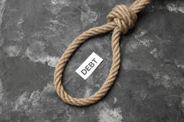 Fototapeta premium Rope with loop and word DEBT on grunge background