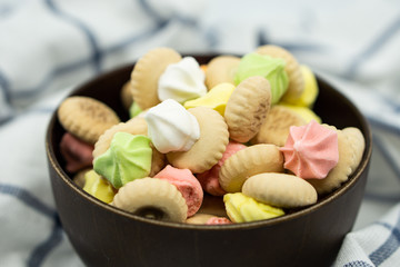 Sugar cookies on a wooden bowl isolated on colorful napkin background.