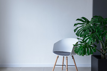 Modern chair near light wall