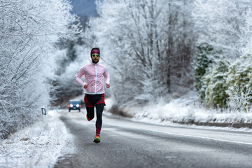 Fototapeta na wymiar Young runner on ice cold road on the Alps