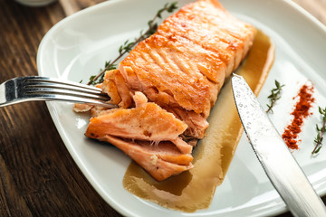 Eating of tasty grilled salmon, closeup