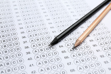 Pencils on blank answer sheet, closeup. Concept of passing exam
