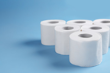 Rolls of toilet paper on color background