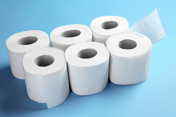 Rolls of toilet paper on color background