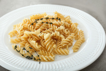Plate with tasty pasta on grey table, closeup