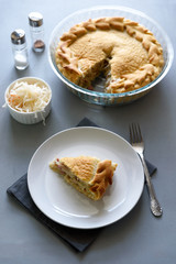 Slice of homemade sauerkraut pie on gray wooden table. Cabbage cake tradition russian food
