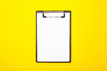 Blank clipboard paper on bright yellow background