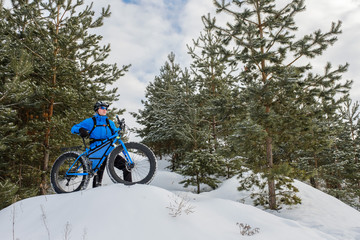 A young man riding fat bicycle in the winter