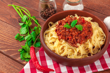 Pasta with meat, tomato sauce and vegetables on the table