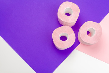 Pastel pink toilet paper on bright color block background