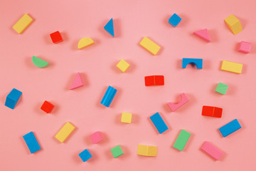 Colorful wooden building blocks coral color background