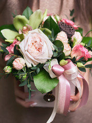 Business woman florist hands holding trendy bouquet composition in box in flower shop