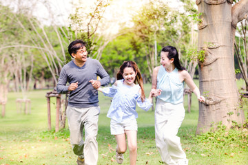 Cheerful family having picnic relaxing together on green nature in park