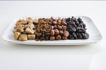 datteri prugne fichi uva passa vassoi fondo bianco