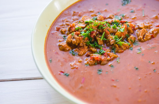 Rindfleischeintopf oder Gulaschsuppe mit Fleischst&uuml;cken in roter Tomaten sauce