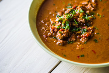 Rindfleischeintopf oder Gulaschsuppe mit Fleischstücken in roter Tomaten sauce