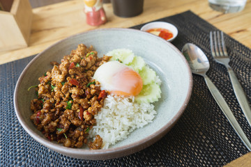 Rice topped with stir fried minced pork and basil. Thaifood concept.  Pad Ka Phrao, fried meat with chili, garlic and holy basil. eat with rice and fried egg. Thai famous food.