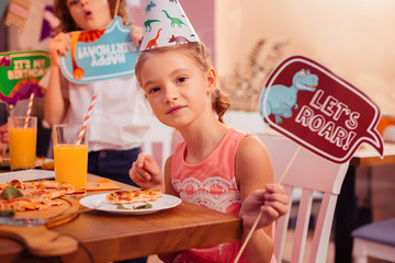 Positive delighted birthday girl looking straight at camera