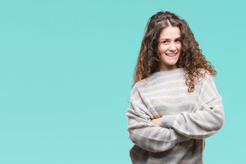 Obraz premium Beautiful brunette curly hair young girl wearing winter sweater over isolated background happy face smiling with crossed arms looking at the camera. Positive person.