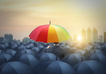 businessman with colorful rainbow umbrella among others, unique different concept