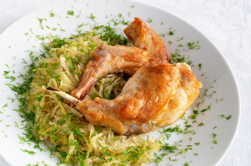 roasted rabbit legs with stewed white cabbage decorated with dill