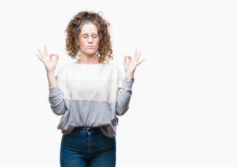 Beautiful brunette curly hair young girl wearing glasses over isolated background relax and smiling with eyes closed doing meditation gesture with fingers. Yoga concept.