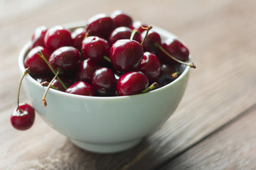 fresh cherries in a plate on a wooden background