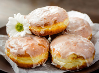 Donuts on a white plate with flower on the table