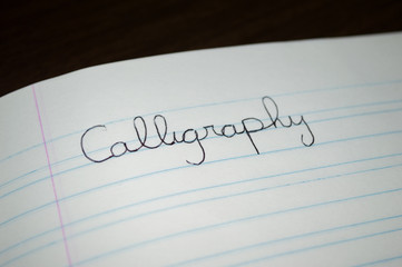 "calligraphy" word written in a practice notebook to improve students and child handwriting letter