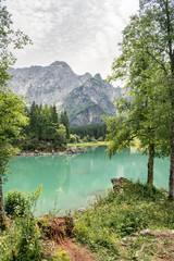 Scenic view of a lake with turquoise or emerald color in northeastern Italy, close to the slovenian border.  One of the two Fusine Lakes in northeastern Italy: an idyllic and peaceful environment.