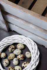 Quail eggs. Lie in a wreath of vines. Next to the wooden box.