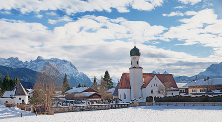 Idyllischer Kurort Wallgau mit Dorfkirche, in verschneiter Landschaft Oberbayern